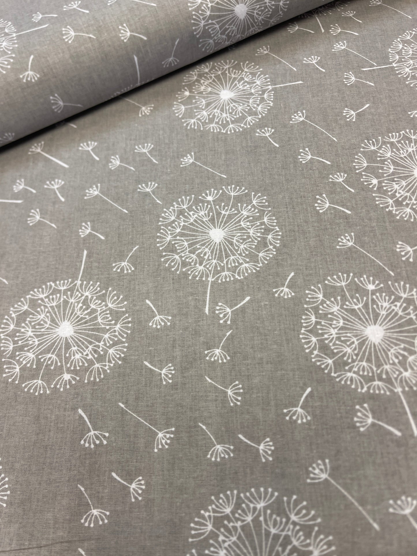 100% Kokvilnas audums - pieneņpūkas uz pelēka fona 125 g/m²