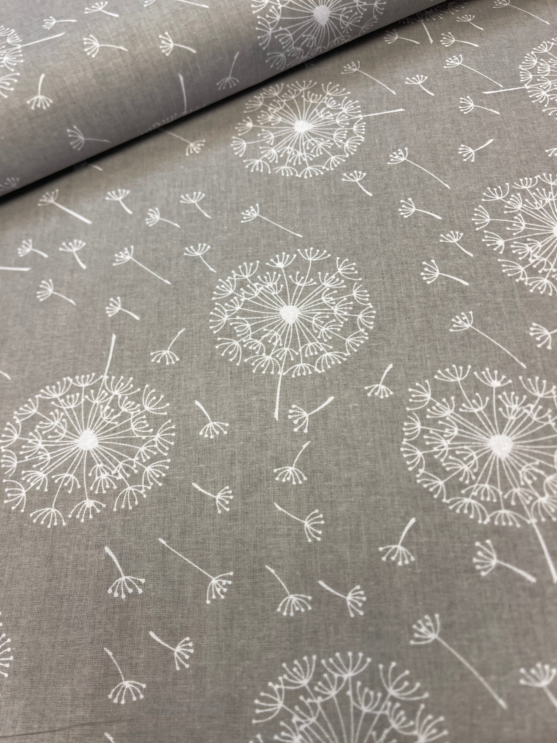 100% Kokvilnas audums - pieneņpūkas uz pelēka fona 125 g/m²