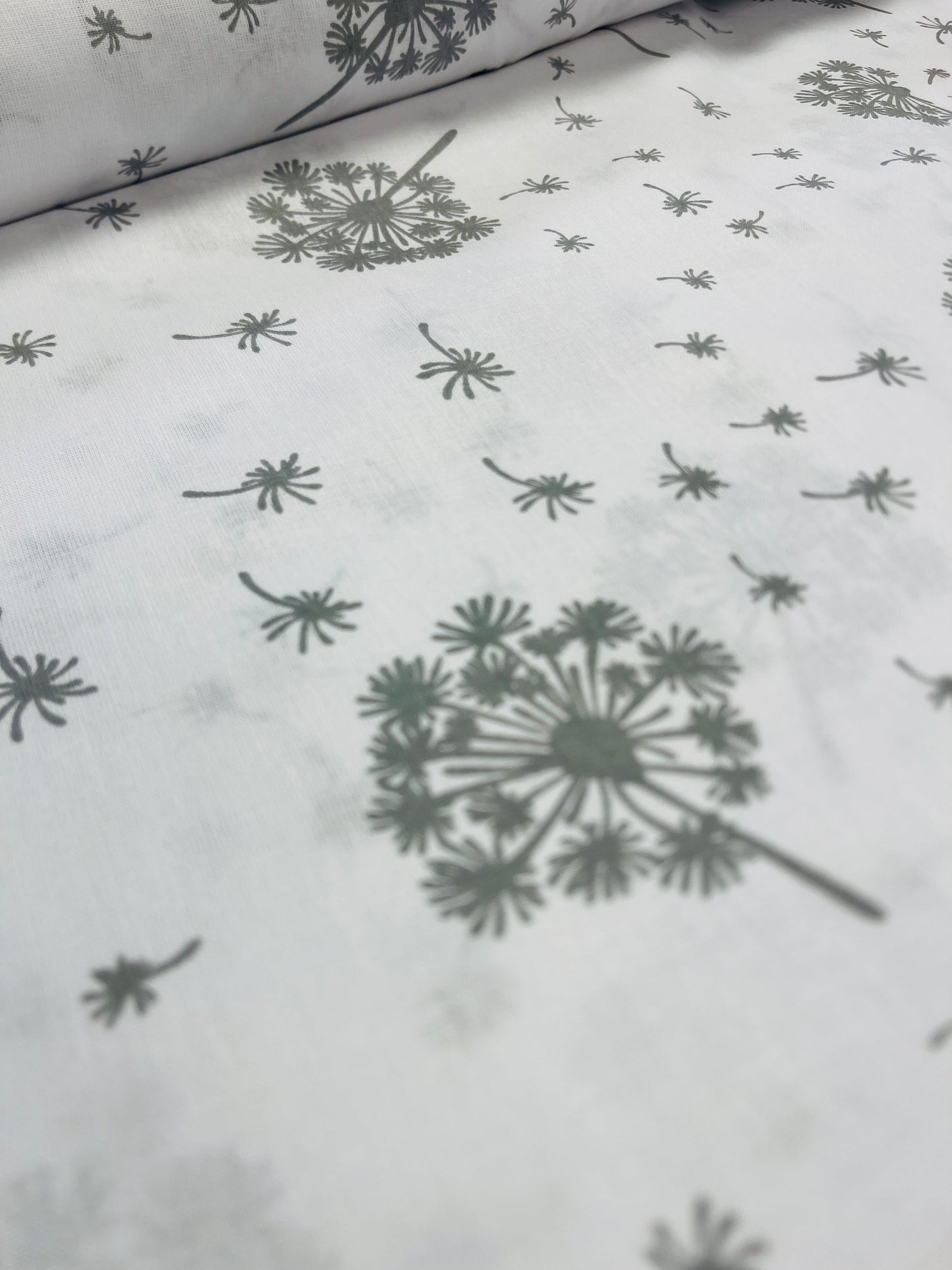 100% Kokvilnas audums - pieneņu pūkas uz balta fona 125 g/m²