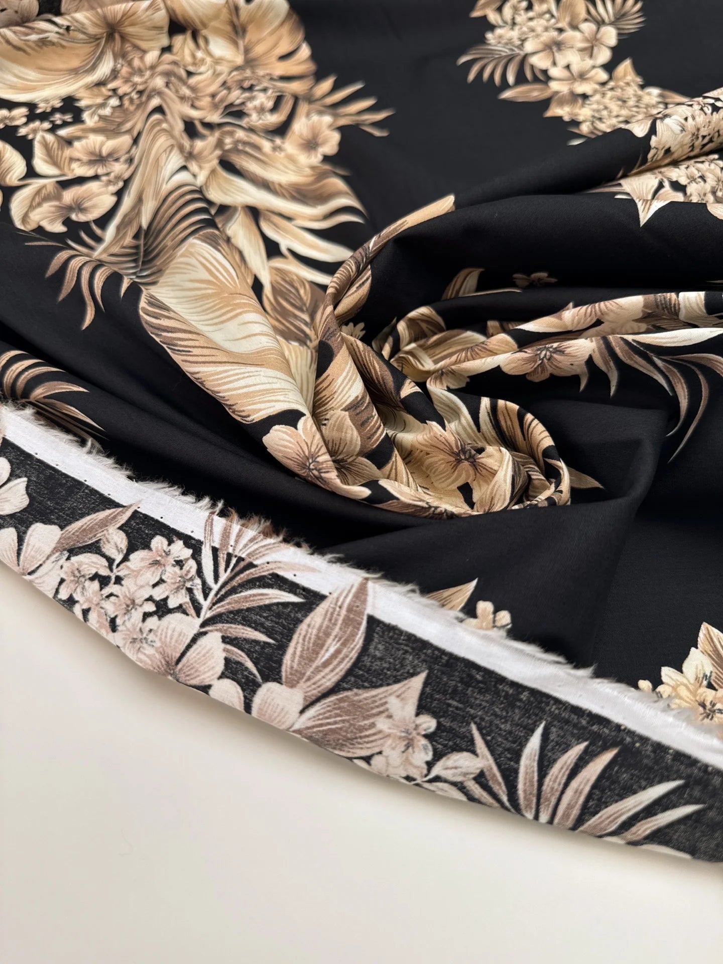 Image of Italian cotton fabric with a tropical floral pattern on a black background – available online at Šarlotes audumi