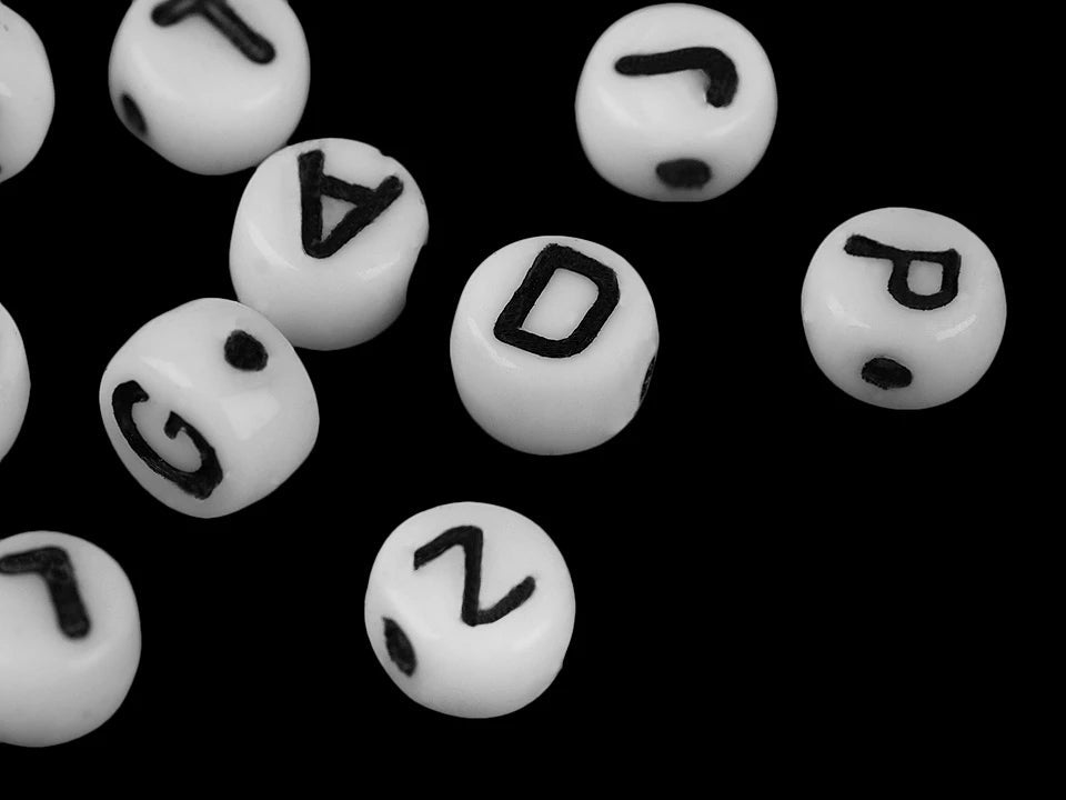 Paveikslėlis su plokščiomis stiklo karoliukėmis su raidėmis – 6 mm, baltomis su juodomis raidėmis – galima įsigyti internetu Šarlotės audiniai