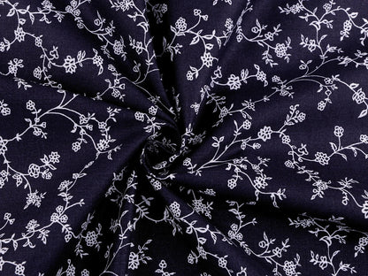 Image avec tissu 100 % coton - motifs floraux blancs sur fond bleu foncé 125 g/m² – disponible chez les tissus de Charlotte