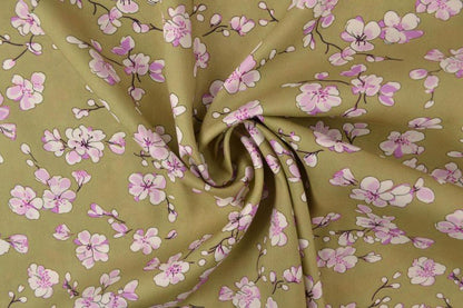 Image of 100% viscose fabric with cherry blossoms on a pistachio green background 100 g/m² – available at Šarlotes audumi