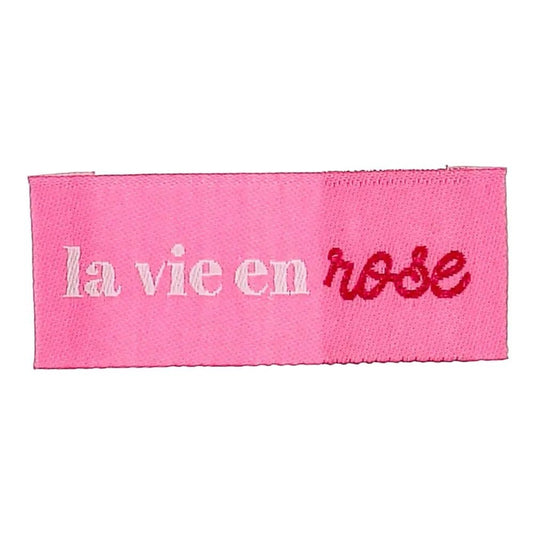 Bohin įsiuvamų drabužių etikečių „La vie en rose“ nuotrauka – žiūrėk į gyvenimą pro rožinius akinius, 2 × 5 cm, 4 vnt. – galima įsigyti internetu „Šarlotes audumi“