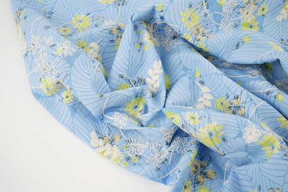 Image de tissu en coton brodé - fleurs jaunes sur fond bleu 115 g/m² – disponible chez Šarlotes audumi